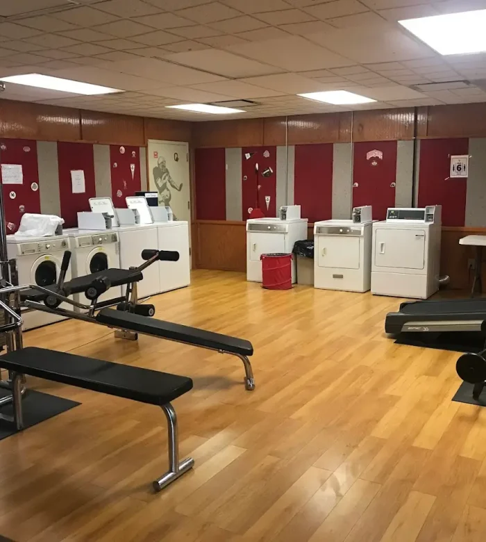 Dual-purpose indoor amenity room at Kountry Resort Campground featuring exercise treadmills, weight lifting benches, and commercial laundry washing machines.